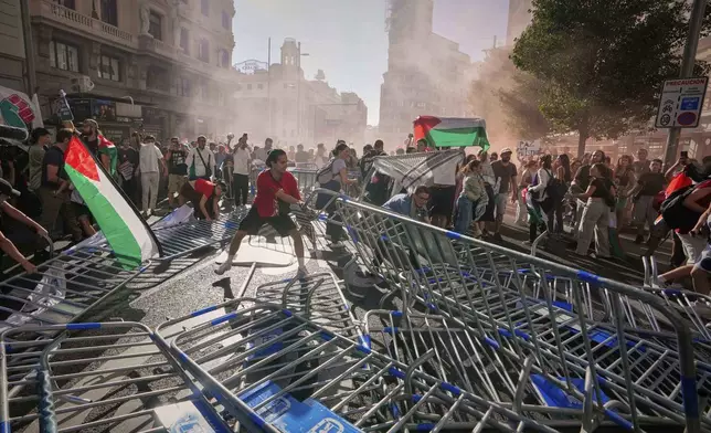 Protesters block the road in an attempt to disrupt the twenty-first stage of the Spanish cycling race La Vuelta, from Alalpardo to Madrid, Spain, Sunday, Sept. 14, 2025. (AP Photo/Manu Fernández)