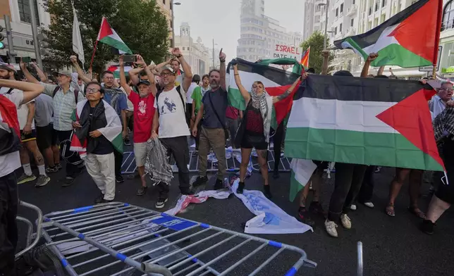 Protesters block the road in an attempt to disrupt the twenty-first stage of the Spanish cycling race La Vuelta, from Alalpardo to Madrid, Spain, Sunday, Sept. 14, 2025. (AP Photo/Manu Fernández)