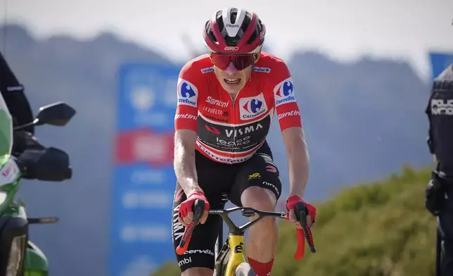 Danish cyclist Jonas Vingegaard completes the final meters before winning the 20th stage and his first overall victory in the Spanish cycling race La Vuelta, from Robledo de Chavela to Bola del Mundo, in Puerto de Navacerrada, Spain, on Saturday, September 13, 2025. (AP Photo/Manu Fernández)