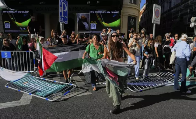 Protesters block the road in an attempt to disrupt the twenty-first stage of the Spanish cycling race La Vuelta, from Alalpardo to Madrid, Spain, Sunday, Sept. 14, 2025. (AP Photo/Manu Fernández)