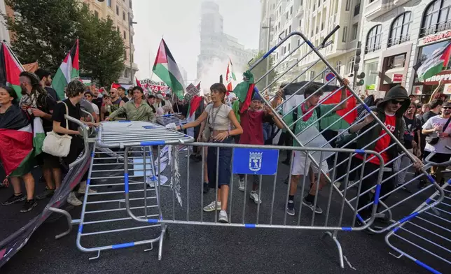 Protesters block the road in an attempt to disrupt the twenty-first stage of the Spanish cycling race La Vuelta, from Alalpardo to Madrid, Spain, Sunday, Sept. 14, 2025. (AP Photo/Manu Fernández)