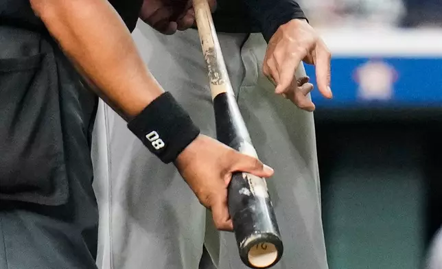 New York Yankees manager Aaron Boone, right, points at Houston Astros' Taylor Trammell's bat held by home plate umpire Adrian Johnson during the ninth inning of a baseball game Thursday, Sept. 4, 2025, in Houston. (AP Photo/Karen Warren)