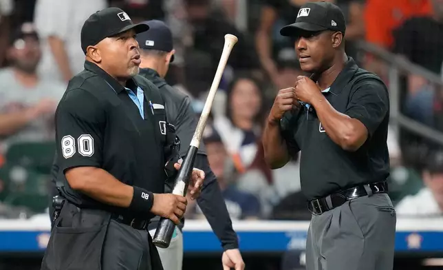 Home plate umpire Adrian Johnson, left, holds Houston Astros' Taylor Trammell's bat as he and Ramon De Jesus, right, were asked by the New York Yankees to challenge the bat during the ninth inning of a baseball game Thursday, Sept. 4, 2025, in Houston. (AP Photo/Karen Warren)