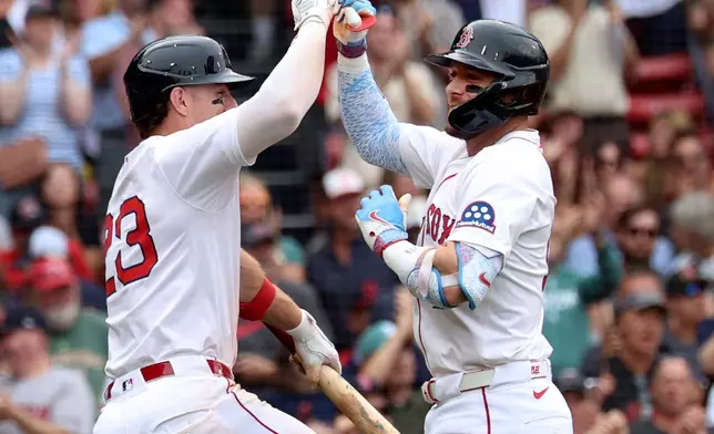 Boston Red Sox's Romy Gonzalez, left, and Trevor Story, right, celebrate after Story's home run during the sixth inning of a baseball game against the Cleveland Guardians, Monday, Sept. 1, 2025, in Boston. (AP Photo/Mark Stockwell)