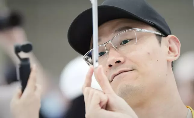 An attendee takes a closer look at the iPhone Air during an announcement of new products at Apple Park on Tuesday, Sept. 9, 2025, in Cupertino, Calif. (AP Photo/Godofredo A. Vásquez)
