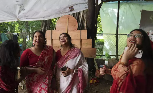 Devotees react upon seeing the idols of the Hindu goddess Durga as they arrive to take them to their place of worship ahead of the Durga Puja festival in New Delhi, India, Sunday, Sept. 21, 2025. (AP Photo/Manish Swarup)