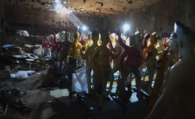 An artist prepares idols of Hindu gods ahead of the Durga Puja festival in New Delhi, India, Saturday, Sept. 20, 2025 (AP Photo/Manish Swarup)