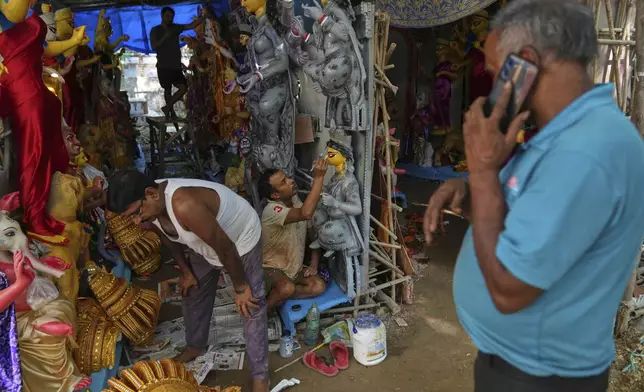 Artists give the final touches to idols of the Hindu goddess Durga ahead of the Durga Puja festival in New Delhi, India, Saturday, Sept. 20, 2025 (AP Photo/Manish Swarup)