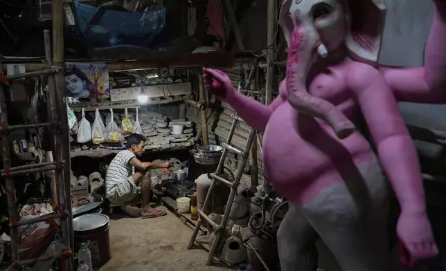 A worker makes tea for fellow artists who are creating idols of Hindu deities ahead of the Durga Puja festival in New Delhi, India, Friday, Sept. 19, 2025. (AP Photo/Manish Swarup)