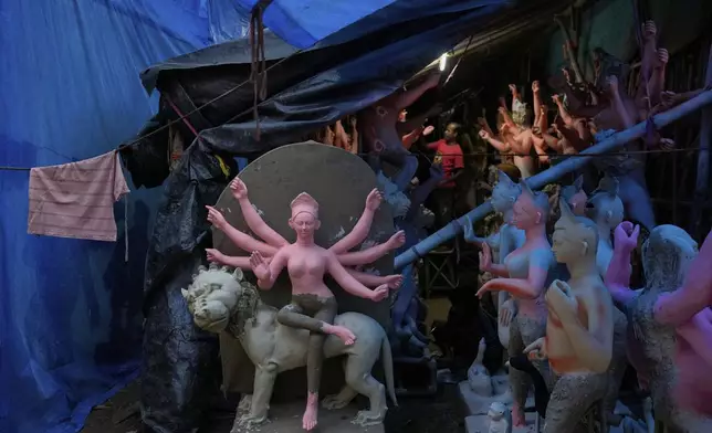 An artist from Kolkata prepares idols of Hindu goddess Durga ahead of the Durga Puja festival, in New Delhi, India, Friday, Sept. 19, 2025. (AP Photo/Manish Swarup)