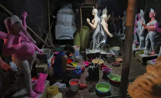 An artist from Kolkata prepares different colors for painting idols of Hindu deities ahead of the Durga Puja festival at a temporary shelter in New Delhi, India, Friday, Sept. 19, 2025. (AP Photo/Manish Swarup)