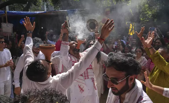 Devotees sing and dance as they gather at a temporary shelter to take an idol of the Hindu goddess Durga to their place of worship ahead of the Durga Puja festival in New Delhi, India, Sunday, Sept. 21, 2025. (AP Photo/Manish Swarup)