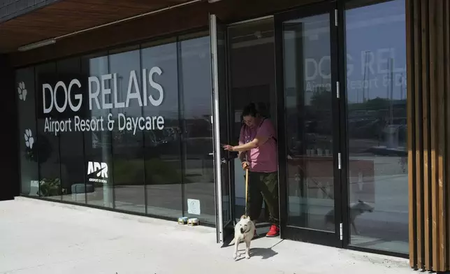 A costumer walks with her dog as she leaves the Dog Relais, a hotel for dogs at Rome's Fiumicino International Airport, Wednesday, Sept. 17, 2025. (AP Photo/Alessandra Tarantino)