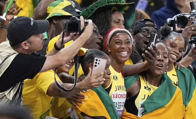 Jamaica's Shelly-Ann Fraser-Pryce and her teammates celebrate with supporters after taking the silver in the women's 4 X 100 meters relay final at the World Athletics Championships in Tokyo, Sunday, Sept. 21, 2025. (AP Photo/Petr David Josek)