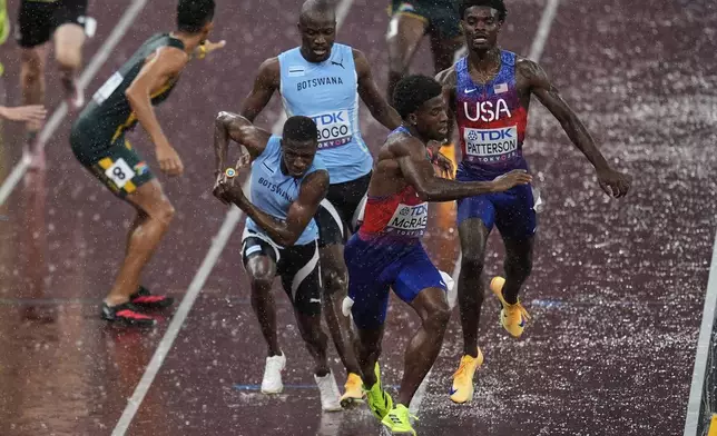 Botswana's Bayapo Ndori receives the baton from Letsile Tebogo as United States' Khaleb McRae receives the baton from United States' Jacory Patterson in the men's 4 X 400 meters relay final at the World Athletics Championships in Tokyo, Sunday, Sept. 21, 2025. (AP Photo/Abbie Parr)