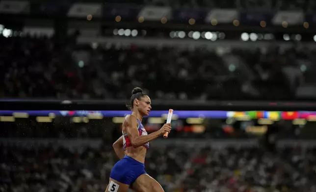 United States' Sydney McLaughlin-Levrone anchors her team to gold in the women's 4 X 400 meters relay at the World Athletics Championships in Tokyo, Sunday, Sept. 21, 2025. (AP Photo/Louise Delmotte)