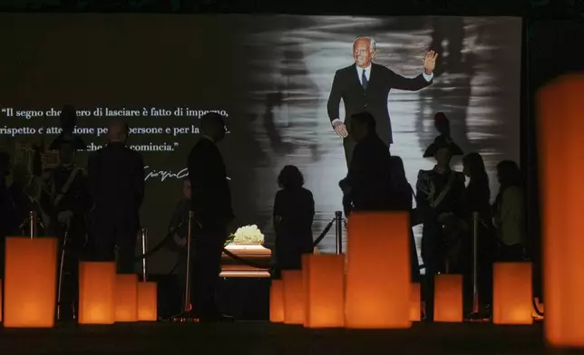 People pay their respects to fashion designer Giorgio Armani, lying in state at the Armani/Teatro in Milan, northern Italy, Saturday, Sept. 6, 2025. (AP Photo/Antonio Calanni)