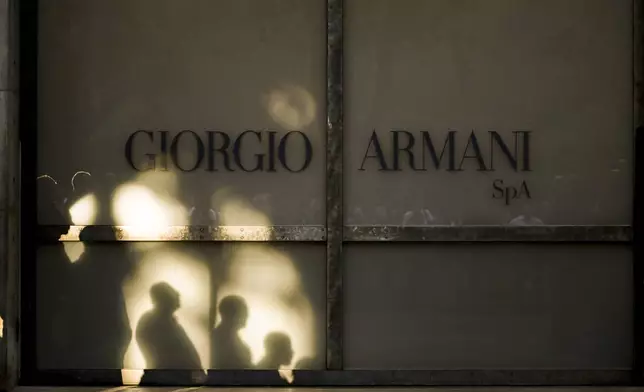Staff of Giorgio Armani Spa gather outside the Armani/Teatro in Milan, northern Italy, as they wait for the hearse with the casket of designer Giorgio Armani, who died Thursday at age 91, Sunday, Sept. 7, 2025. (AP Photo/Nicola Marfisi)