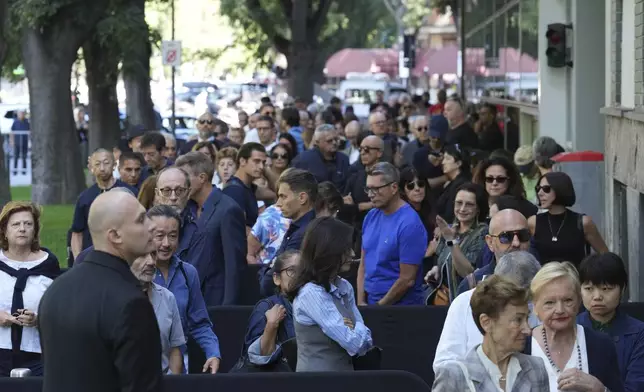 CORRECTS DATE - People line up in Milan, northern Italy, Saturday, Sept. 6, 2025, to pay their respects to fashion designer Giorgio Armani, who died Thursday at age 91. (AP Photo/Antonio Calanni)