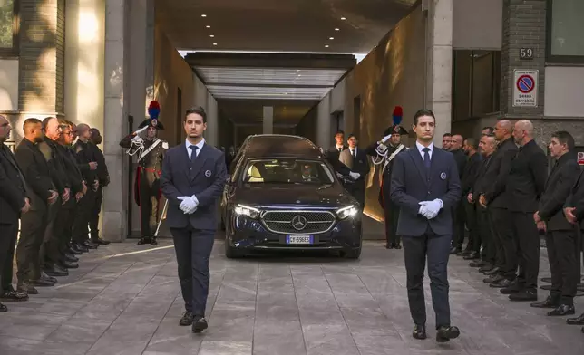 Staff of Giorgio Armani Spa gather outside the Armani/Teatro in Milan, northern Italy, as the hearse with the casket of designer Giorgio Armani, who died Thursday at age 91, leaves, Sunday, Sept. 7, 2025. (AP Photo/Nicola Marfisi)
