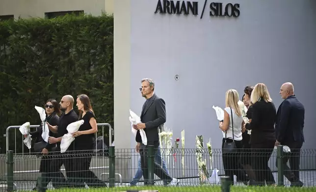 Employees arrive at the Armani/Teatro in Milan, northern Italy, to pay their respects to designer Giorgio Armani, who died Thursday at age 91, Saturday, Sept. 6, 2025. (AP Photo/Nicola Marfisi)