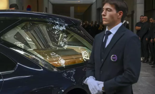 Staff of Giorgio Armani Spa gather outside the Armani/Teatro in Milan, northern Italy, as the hearse with the casket of designer Giorgio Armani, who died Thursday at age 91, leaves, Sunday, Sept. 7, 2025. (AP Photo/Nicola Marfisi)