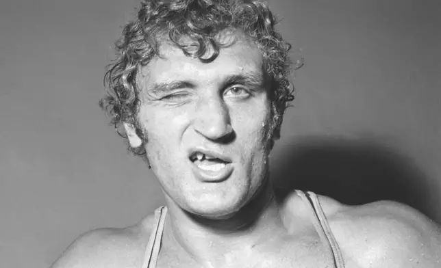 FILE - British Heavyweight boxer Joe Bugner winks towards the camera, after completing his daily training session at the British Boxing Board of Control's gymnasium at Chalk Farm, London, on Oct. 5, 1972. (AP Photo/Bob Dear, file)