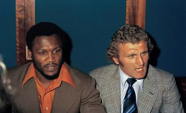 FILE - Joe Bugner, British heavyweight boxing champion, right, is pictured with American boxer Joe Frazier at a news conference at the Sportsman Club in London, June 1973, prior to their bout. (AP Photo, file)