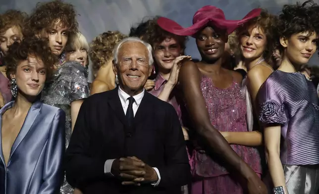FILE - Designer Giorgio Armani, centre, poses with models at the end of his women's 2019 Spring-Summer collection, unveiled during the Fashion Week in Milan, Italy, Sunday, Sept. 23, 2018. (AP Photo/Luca Bruno, File)