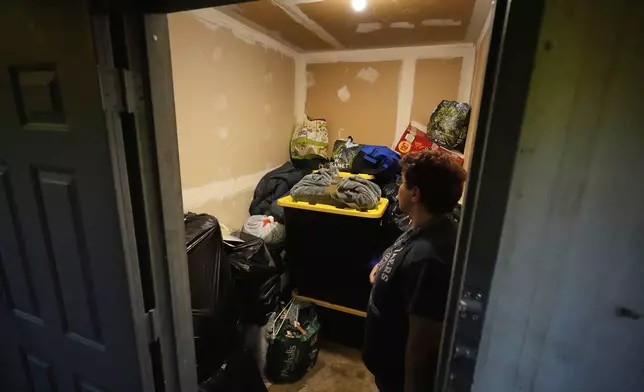Maria Pires’ belongings are in a storage unit, and Pires' friend Liz Silva stands by it in Baltimore, Wednesday, June 25, 2025 (AP Photo/Stephanie Scarbrough)