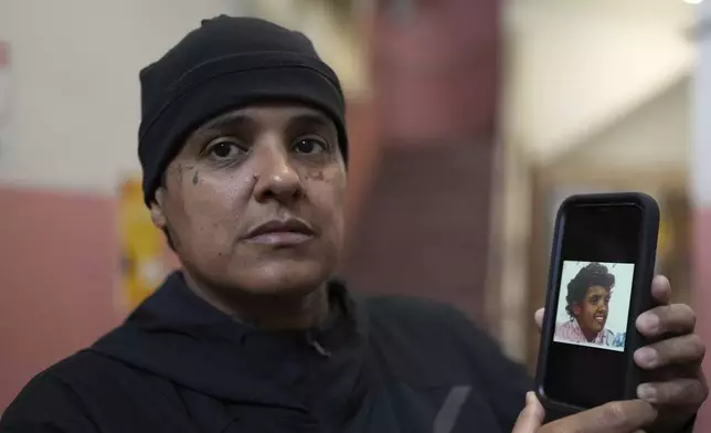 Maria Pires holds a picture of herself at age 11 as she gives an interview at the shelter where she is staying in eastern Brazil, Sunday, June 15, 2025, after her deportation from the U.S. (AP Photo/Andre Penner)