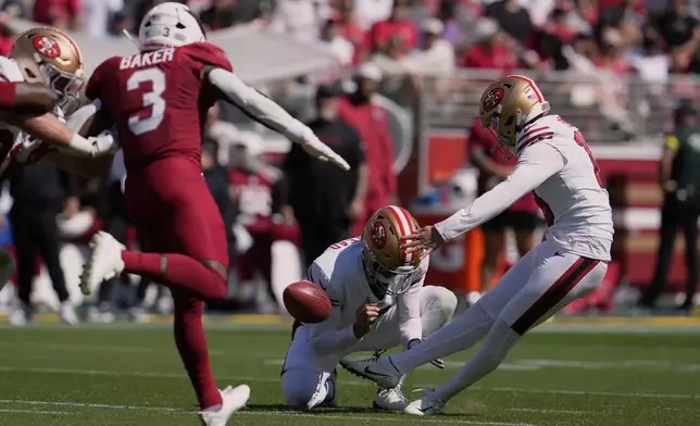 San Francisco 49ers kicker Eddy Piñeiro, right, kicks a field goal as Arizona Cardinals safety Budda Baker runs in during the first half of an NFL football game Sunday, Sept. 21, 2025, in Santa Clara, Calif. (AP Photo/Godofredo A. Vásquez)