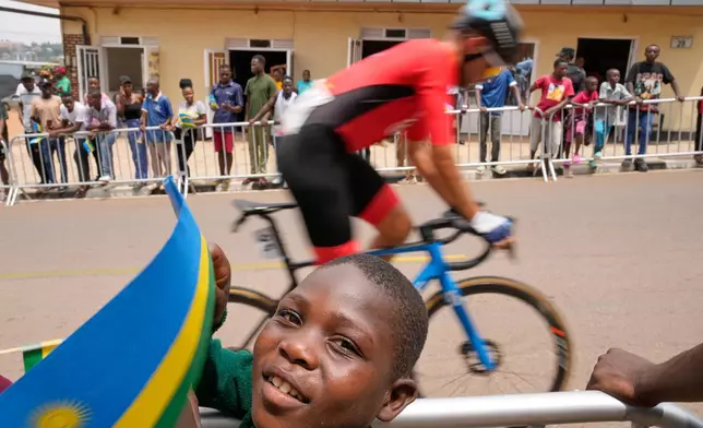 Spectators cheer as competitors ride past during the men's Under 23 road race, at the road cycling World Championships in Kigali, Rwanda, Friday, Sept. 26, 2025. (AP Photo/Jerome Delay)