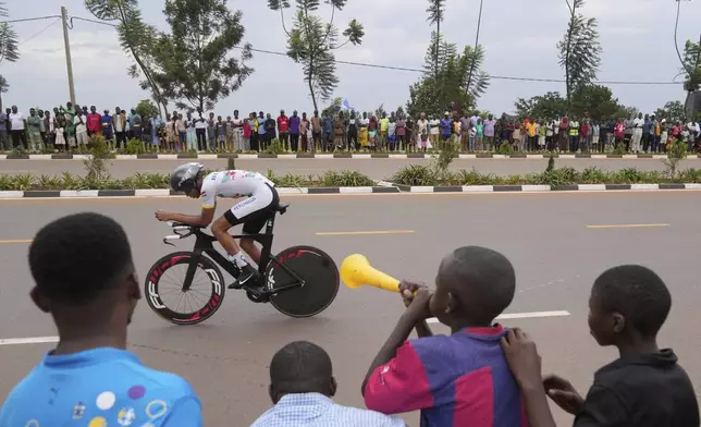 Seychelles' Jahdel Gabriel is cheered by spectators as he pedals during the men's Under 23 individual time trial event, at the road cycling World Championships in Kigali, Rwanda, Monday, Sept. 22, 2025. (AP Photo/Jerome Delay)