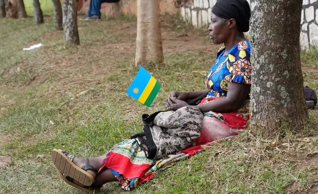 A woman sits by the road as she watches the women's Under 23 race, at the road cycling World Championships in Kigali, Rwanda, Thursday, Sept. 25, 2025. (AP Photo/Jerome Delay)