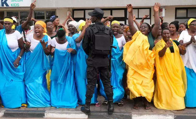 Women cheer during the team time trial mixed relay event, at the road cycling World Championships in Kigali, Rwanda, Wednesday, Sept. 24, 2025. (AP Photo/Jerome Delay)