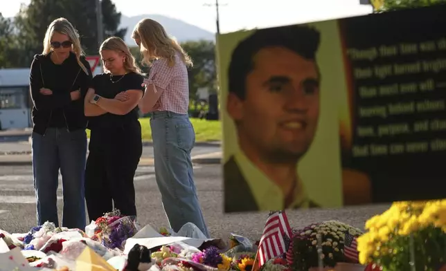 Women pray at a memorial outside Utah Valley University after Turning Point USA CEO and co-founder Charlie Kirk was shot and killed, Saturday, Sept. 13, 2025, in Orem, Utah. (AP Photo/Lindsey Wasson)