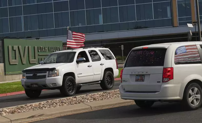 A truck drives by with "Justice for Charlie" written on a window as a brigade of vehicles drives by in tribute to Turning Point USA CEO and co-founder Charlie Kirk at Utah Valley University, Saturday, Sept. 13, 2025, in Orem, Utah. (AP Photo/Lindsey Wasson)