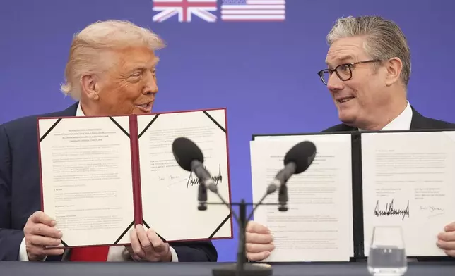 President Donald Trump and Britain's Prime Minister Keir Starmer smile, holding a memorandum of understanding between the governments of the two countries after a business roundtable at Chequers near Aylesbury, England, Thursday, Sept. 18, 2025. (AP Photo/Evan Vucci)