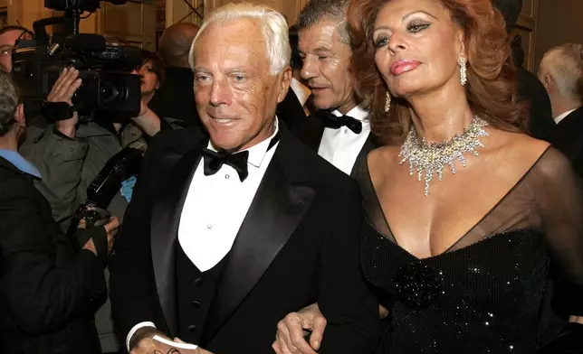 FILE - Italian actress Sophia Loren, right, and fashion designer Giorgio Armani arrive for the reopening of La Scala theater in Milan, Dec. 7, 2004. (AP Photo/Luca Bruno, File)