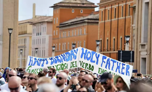 Faithful display a banner wishing happy 70th birthday to Pope Leo XIV as he appears at his studio's window to bless the faithful gathered in St. Peter's Square at the Vatican for the Angelus prayer, Sunday, Sept. 14, 2025. (AP Photo/Gregorio Borgia)