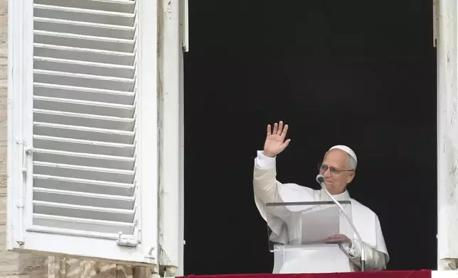 Pope Leo XIV appears at his studio's window to bless the faithful gathered in St. Peter's Square at the Vatican for the Angelus prayer, Sunday, Sept. 14, 2025. (AP Photo/Gregorio Borgia)