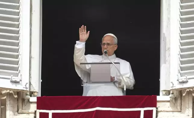 Pope Leo XIV appears at his studio's window to bless the faithful gathered in St. Peter's Square at the Vatican for the Angelus prayer, Sunday, Sept. 14, 2025. (AP Photo/Gregorio Borgia)