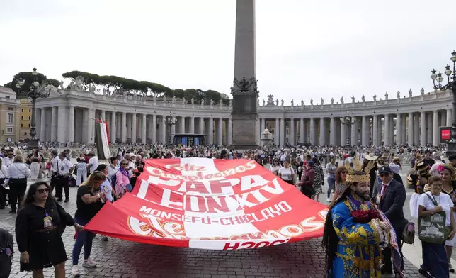 Faithful from Peru display a banner wishing happy 70th birthday to Pope Leo XIV with a statue of Jesus Nazareno Cautivo de Monsefu, as he appears at his studio's window to bless the faithful gathered in St. Peter's Square at the Vatican for the Angelus prayer, Sunday, Sept. 14, 2025. (AP Photo/Gregorio Borgia)