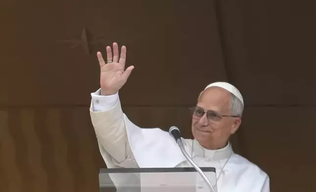 Pope Leo XIV appears at his studio's window to bless the faithful gathered in St. Peter's Square at the Vatican for the Angelus prayer, Sunday, Sept. 14, 2025. (AP Photo/Gregorio Borgia)