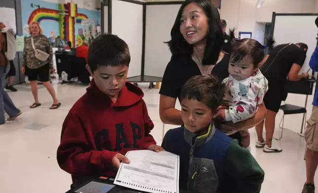 Boston Mayor Michelle Wu votes with her children Blaise, Cass and Mira, from left, at a polling place, Tuesday, Sept. 9, 2025, in the Roslindale neighborhood of Boston. (AP Photo/Charles Krupa)