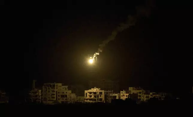 An Israeli army flare drifts over buildings destroyed during the Israeli ground and air operations in the northern Gaza Strip, as seen from southern Israel, Monday, Sept. 15, 2025. (AP Photo/Leo Correa)