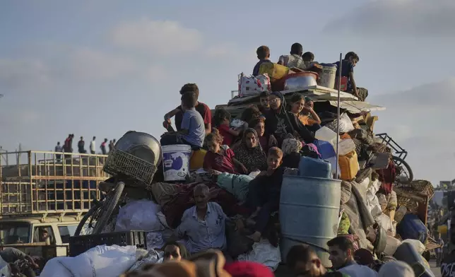 Displaced Palestinians flee northern Gaza by foot and in vehicles, carrying their belongings along the coastal road toward southern Gaza, Monday, Sept. 15, 2025. (AP Photo/Abdel Kareem Hana)