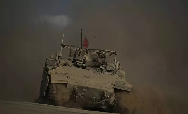 An Israeli armored vehicle moves along the Israeli-Gaza border as seen from southern Israel, Tuesday, Sept. 16, 2025. (AP Photo/Leo Correa)