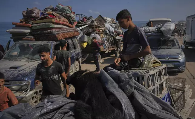 Displaced Palestinians carry their belongings as they flee northern Gaza along the coastal road toward the south, as Israel announced an expanded operation in Gaza City, Tuesday, Sept. 16, 2025. (AP Photo/Abdel Kareem Hana)